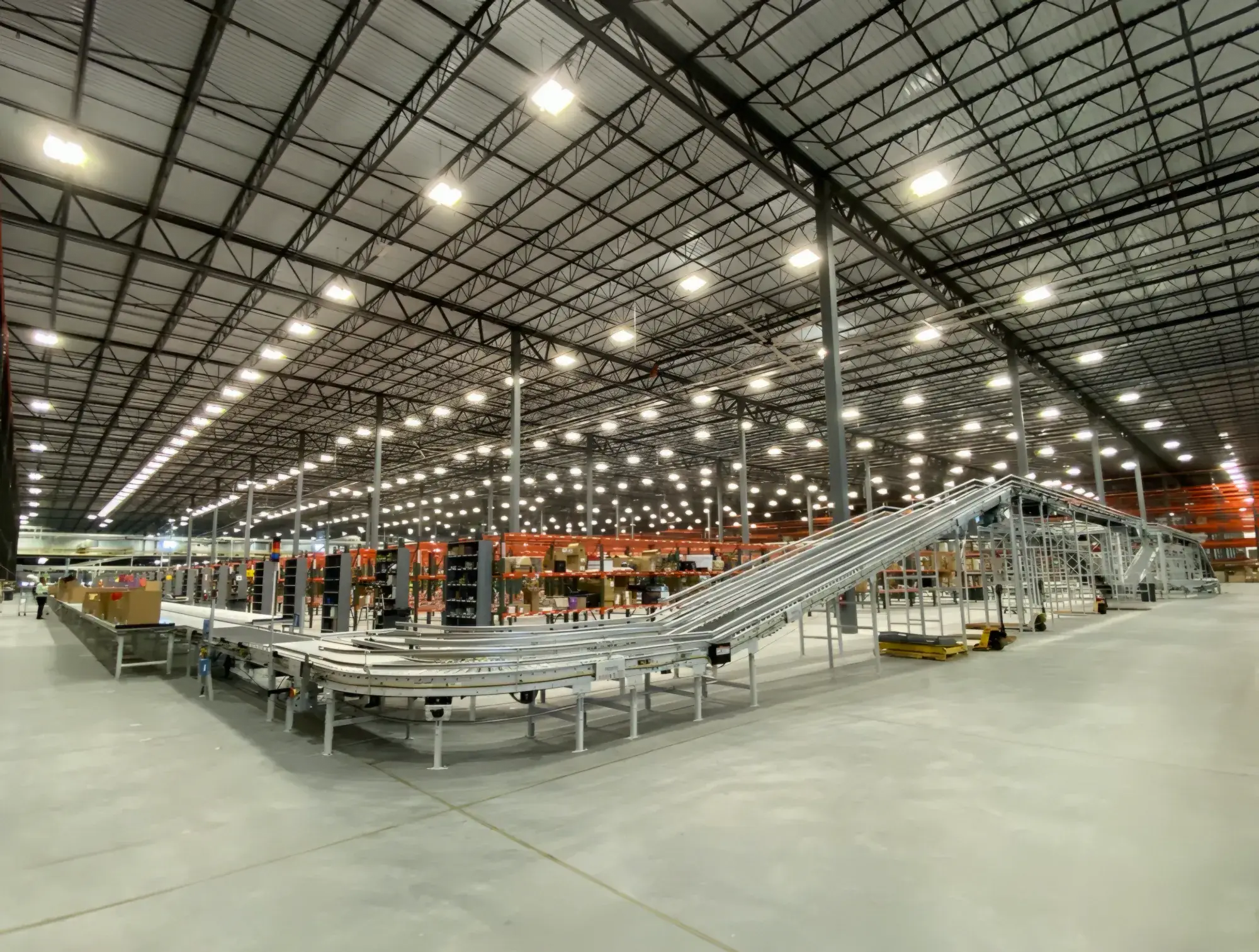 Inside one of the distribution centers we operate: a powered sortation conveyor runs the length of a high-bay warehouse floor.